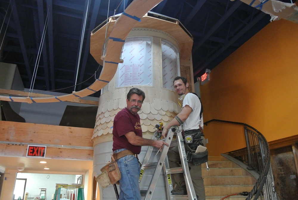 Dos personas construyen la primera exposición interior del Museo de los Niños hacia 2015