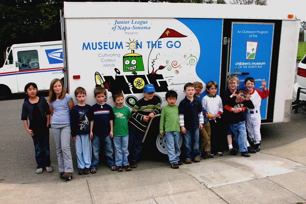 Niños jugando con actividades interactivas y educativas llevadas a eventos comunitarios locales por el programa Museum-on-the-Go entre 2005 y 2010.